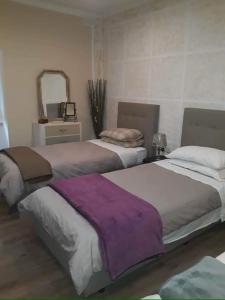 twee bedden in een kamer met een spiegel bij Modern two bedroom apartment in Valletta in Is-Swatar