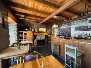 a bar with wooden walls and wooden tables and chairs at Casa Uishera in Vilamós