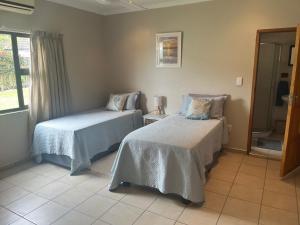 a bedroom with two beds and a window at Sibiya Guest House in Sodwana Bay +20 photos