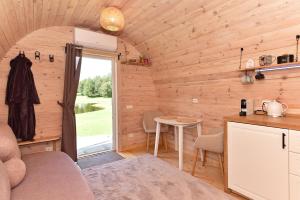a kitchen and living room in a tiny house at Mileikių sodyba namelis dviems in Šarkiškės