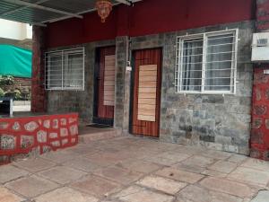 una casa roja con una puerta y ventanas rojas en Leela villa - Ancient Redstone Escape, en Panchgani
