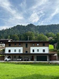 a large building with two cars parked in front of it at Haus Steinplatte in Waidring