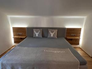 a bedroom with a large bed with two pillows at Haus Steinplatte in Waidring
