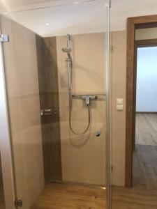 a shower in a bathroom with a glass door at Haus Steinplatte in Waidring +12 photos