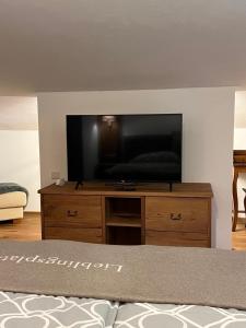 a flat screen tv sitting on top of a wooden dresser at Haus Steinplatte in Waidring