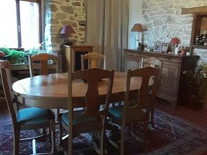 a dining room with a wooden table and chairs at Chambre double chez Emilienne 