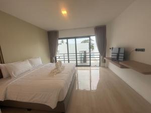 a bedroom with a bed and a large window at Pine Bungalow Krabi in Klong Muang Beach