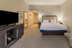 a hotel room with a bed and a flat screen tv at Hampton Inn Jasper, AL in Jasper