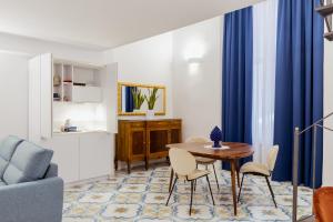 a living room with a table and chairs at Atri Rooms Centro Storico Napoli in Naples