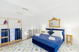 a bedroom with a blue bed and a mirror at Atri Rooms Centro Storico Napoli in Naples