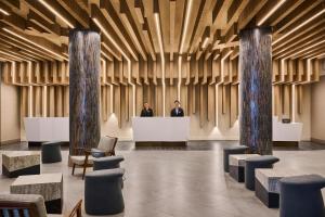 dos hombres parados en un mostrador en un vestíbulo en Hilton Anchorage, en Anchorage 57 fotos más