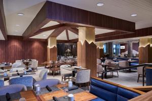 Un restaurante con mesas y sillas de madera y un escritorio. en Hilton Anchorage, en Anchorage