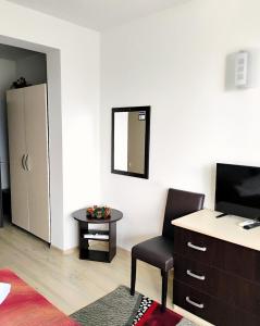 a room with a chair and a desk and a mirror at Pensiunea Carmen - Bikers Friendly Nest in Sibiu +83 photos