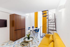 a living room with a yellow couch and a table at Atri Rooms Centro Storico Napoli in Naples