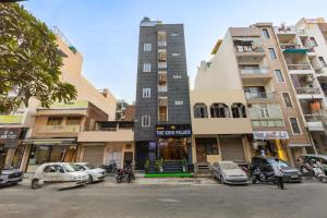 a tall building with cars parked in front of it at Hotel The King Palace in New Delhi