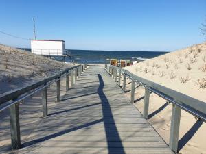a shadow of a person on a boardwalk on the beach at Ostseepark in Zempin