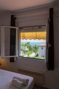 a bedroom window with a view of a house at Cookoo Villas in Kriopigi