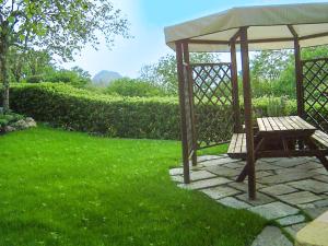 a wooden gazebo with a bench in a yard at Casa Marica in Porto Valtravaglia