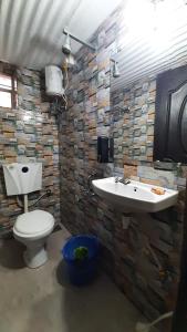 un baño con inodoro y lavabo en Leela villa - Ancient Redstone Escape, en Panchgani