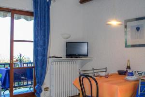 a dining room with a table and a tv on the wall at Casa Marica in Porto Valtravaglia
