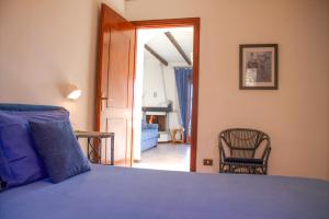 a bedroom with a blue bed and a chair at Casa Marica in Porto Valtravaglia