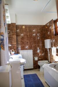 a bathroom with a toilet and a sink and a tub at Casa Marica in Porto Valtravaglia