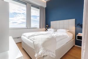 a bedroom with a large white bed with a blue wall at Skyline City Loft in Vienna