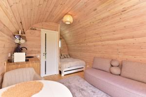 a living room with a couch and a bedroom at Mileikių sodyba namelis dviems in Šarkiškės
