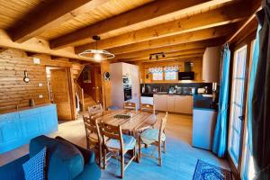 eine Küche und ein Esszimmer mit einem Holztisch und Stühlen in der Unterkunft BEAUTIFUL CHALET in nature near Gerardmer! in Rochesson