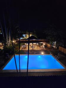 a large blue swimming pool at night at Reef Hostel in Puerto Princesa City