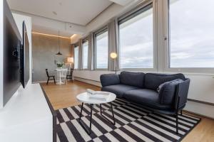 a living room with a couch and a table at Exklusives Skyline-View Loft - Nähe Zentrum Wien in Vienna