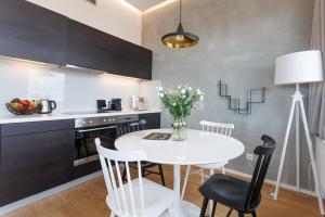 a kitchen and dining room with a white table and chairs at Exklusives Skyline-View Loft - Nähe Zentrum Wien in Vienna