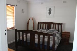 una camera da letto con un letto di legno e una finestra di Paradise at Port Hughes - Family Beach Escape a Port Hughes