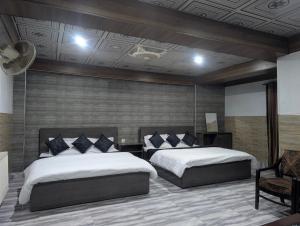 Un pat sau paturi într-o cameră la But Tourist Inn Hotel Murree