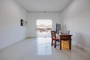 Habitación blanca con escritorio y mesa con silla. en RedDoorz near Ubud Village, en Sukawati
