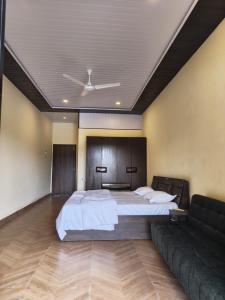 ein Schlafzimmer mit einem großen Bett und einer Couch in der Unterkunft Kalyani Village Resort in Khanivde