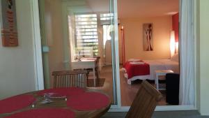 una stanza con tavolo e una camera da letto di Résidence de la Vielle Tour - Studio particulier vue mer a Le Gosier