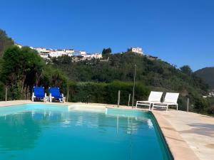 a swimming pool with two lawn chairs and two chairs at Sonho No Mondego in Penacova