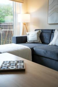 a living room with a blue couch and a table at Stobhill Apartment in Glasgow