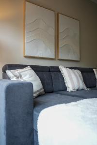 a blue couch with white pillows in a living room at Stobhill Apartment in Glasgow
