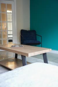 a wooden coffee table in a living room with a chair at Stobhill Apartment in Glasgow
