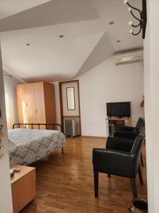 a bedroom with a bed and a chair and a couch at Apartmani Stipanic Tivat in Tivat