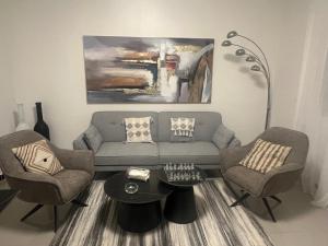 a living room with a couch and two chairs and a table at Farid Street - Studio - Dakar Plateau in Dakar