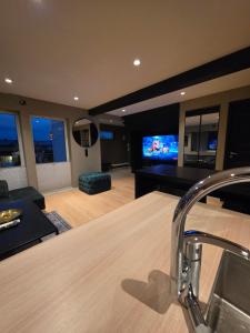 a living room with a couch and a flat screen tv at Aurora View Apartment - Free Parking & Walkable City Location in Tromsø