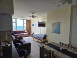 a living room with a couch and a table at Peacehaven Beachfront Property - Scottburgh KZN in Scottburgh