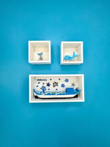 a blue wall with three pictures of a boat at Hospedatom - Apartamento Economy Prainha Arraial do Cabo in Arraial do Cabo
