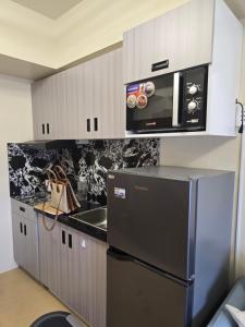 a kitchen with a refrigerator and a microwave at Casa Istilo Studio at Avida Abreeza Davao in Davao City