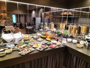 a buffet with many plates of food on a table at Nova Hotel in Radom