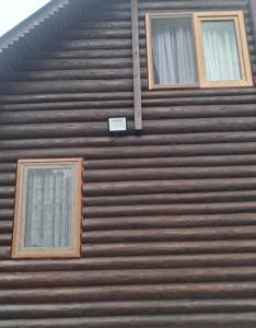 twee ramen aan de zijkant van een houten gebouw bij SUN vikendica in Rožaje