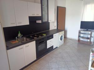 a kitchen with a sink and a stove top oven at Da Nanni in Villasimius